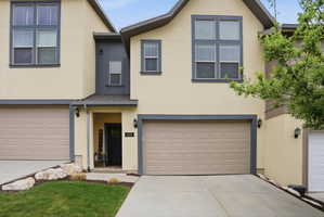 Stucco exterior with contrasting trim, featuring an integrated two-car garage