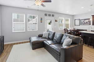 Open-concept living space featuring wood-finish flooring, recessed lighting, and a ceiling fan