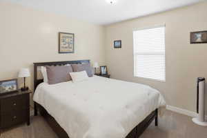 Carpeted room featuring neutral-toned walls, a single window with blinds, and a ceiling-mounted light fixture