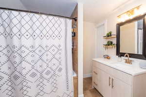 Primary Suite Bathroom featuring a light wood-finish vanity with a white countertop and an undermount sink