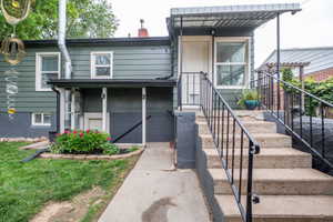 Rear exterior with durable siding, concrete steps, and a sheltered entry