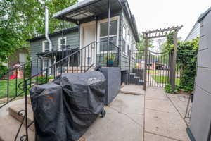 Rear exterior featuring horizontal siding, a covered entry, and black iron railings