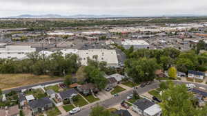 Residential street with single-story homes featuring a mix of roof styles and mature trees, Sunset views