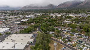 Expansive aerial perspective showcasing a residential neighborhood with surrounding commercial developments, set against a backdrop of distant mountains