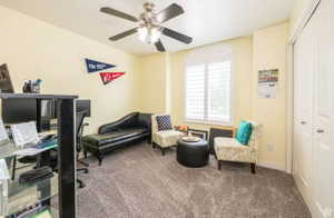 Carpeted room featuring a ceiling fan with integrated lighting, a large window with plantation shutters, and a bi-fold closet door