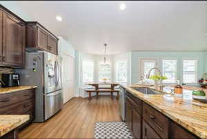 Expansive kitchen island featuring a stainless steel sink and a gooseneck faucet