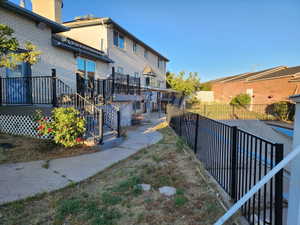 Rear exterior featuring a multi-level deck with black railings, white lattice skirting, and concrete pathways