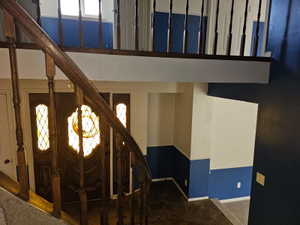 Grand foyer entry featuring a dark wood door with stained-glass window accents and matching sidelights