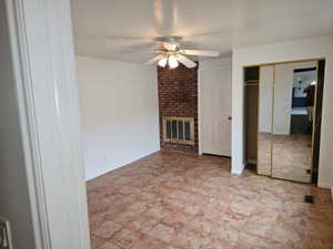 Neutral-toned tile flooring throughout with a brick fireplace feature