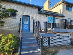 Multi-level exterior deck featuring composite decking, black metal railings, and a white lattice base