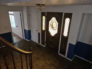 Entryway featuring a wood door with stained-glass inserts, coordinating side lights, and a crystal chandelier