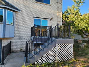 Exterior staircase featuring black metal railings and a white lattice skirt