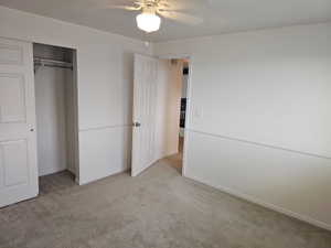 Carpeted room with a ceiling fan light fixture
