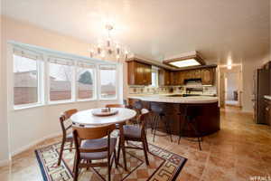 Kitchen and dining area featuring a curved breakfast bar, tile flooring, and a bay window