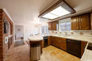 Kitchen featuring tile flooring, wood cabinetry, a built-in oven, and a breakfast bar with a tile countertop