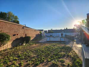 Expansive outdoor area featuring a fenced swimming pool, concrete patio, and a sloped lawn area