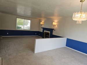 Spacious carpeted room featuring a built-in fireplace with a blue surround