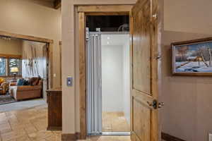Hall featuring stone tile flooring and elevator