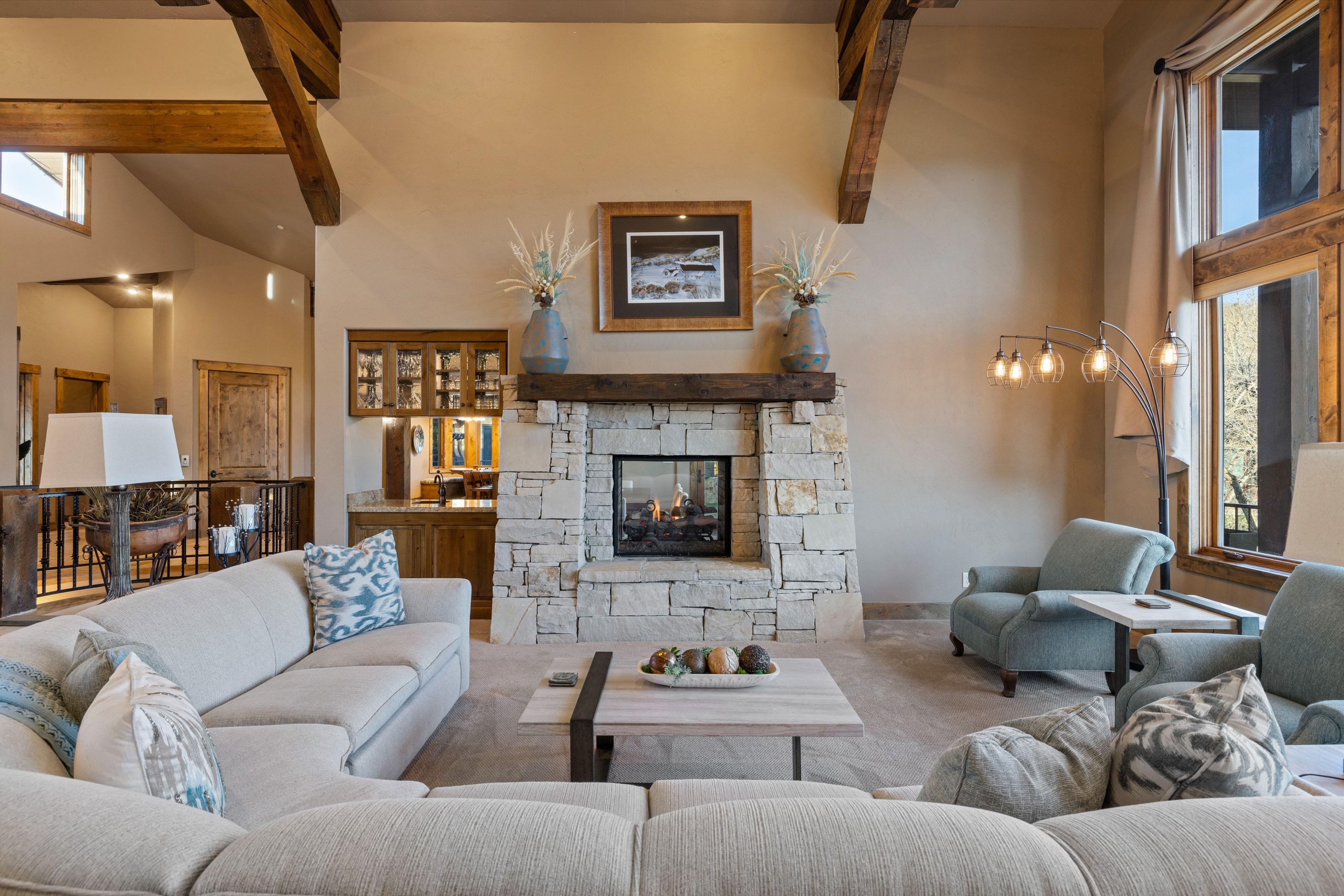 Carpeted living area with a stone fireplace