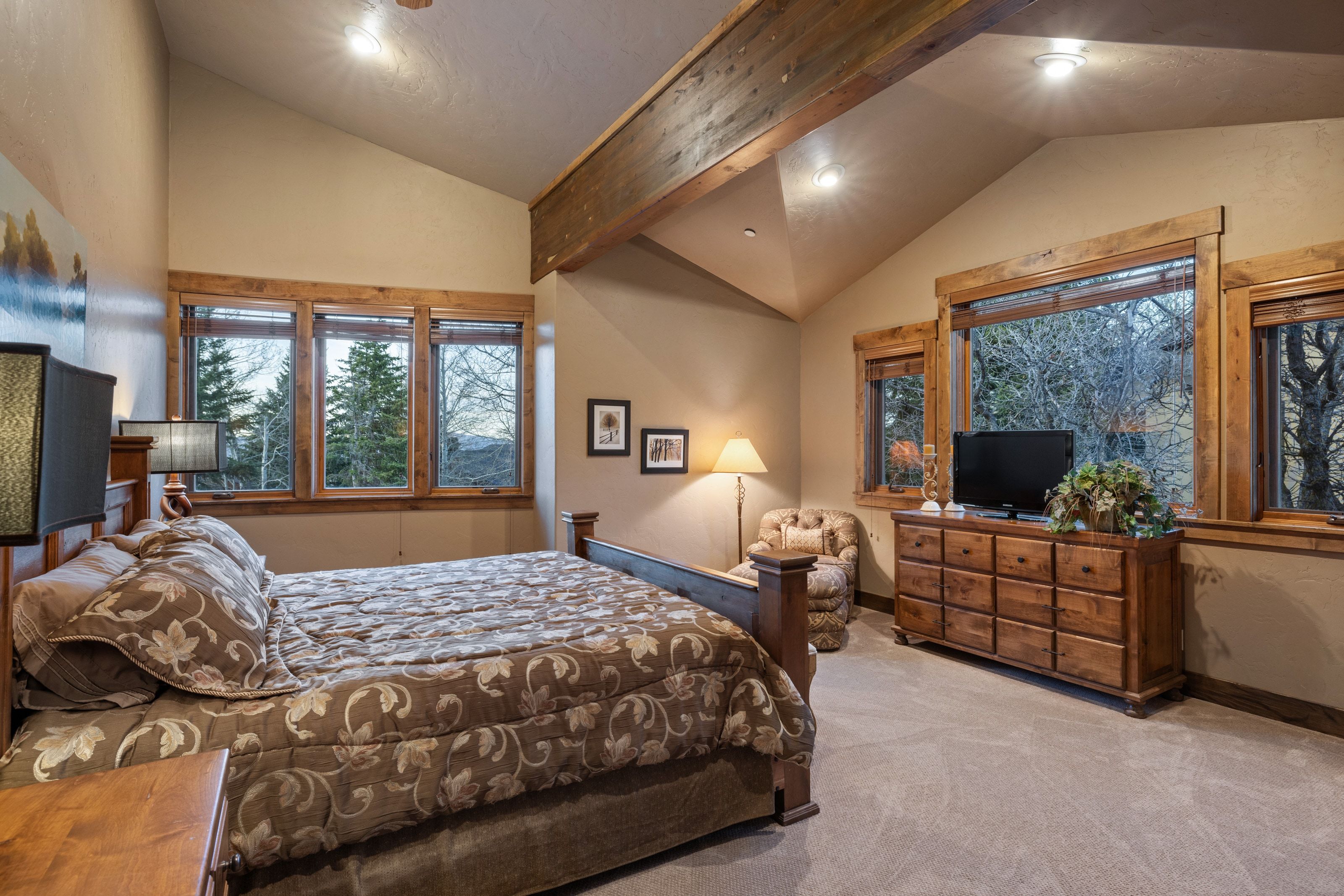 Bedroom featuring lofted ceiling with beams, recessed lighting, and light colored carpet