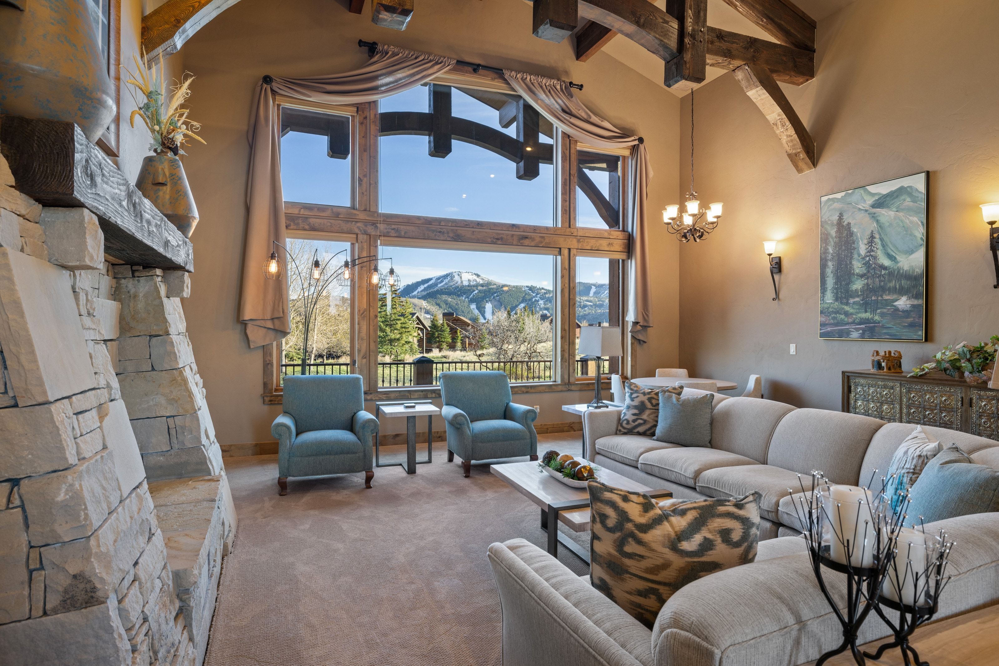 Living room featuring a mountain view, carpet flooring, a fireplace, hanging lights, and vaulted ceiling