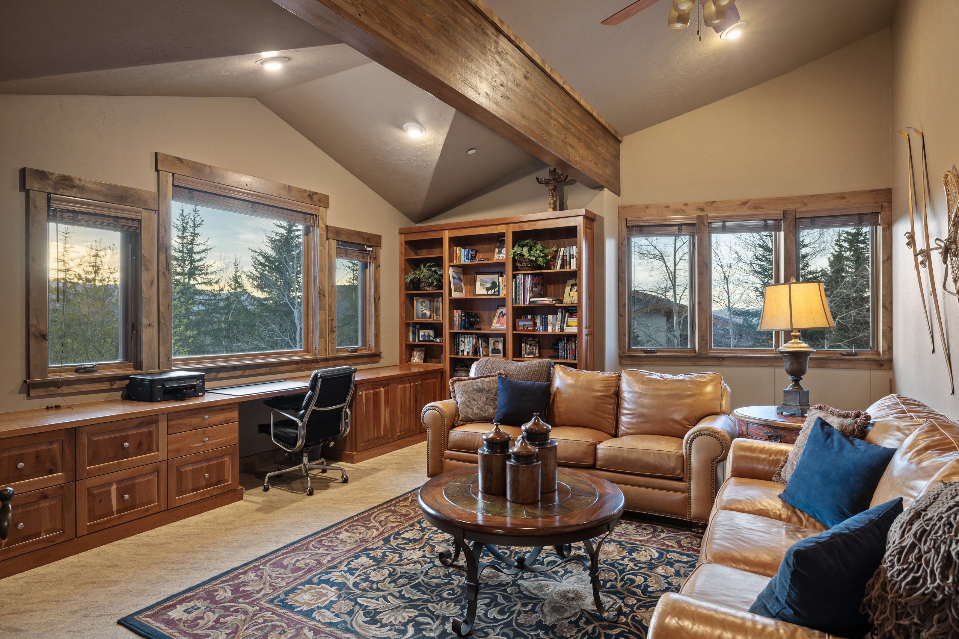 Carpeted office space featuring vaulted ceiling with beams, a ceiling fan, built in desk, and recessed lighting