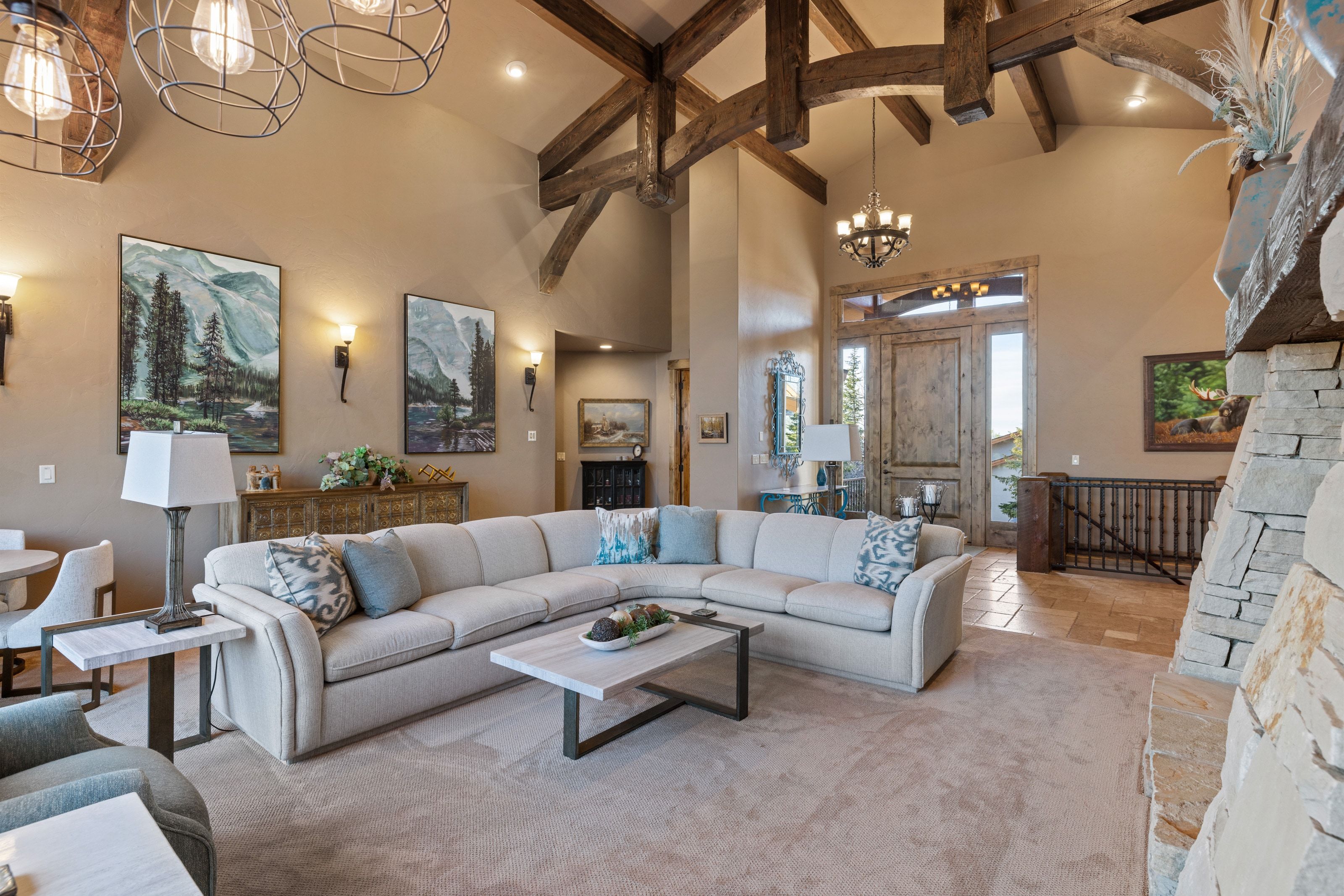 Carpeted living area with hanging lights and vaulted ceiling