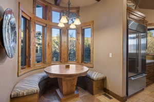Dining room featuring stone tile flooring and hanging lights
