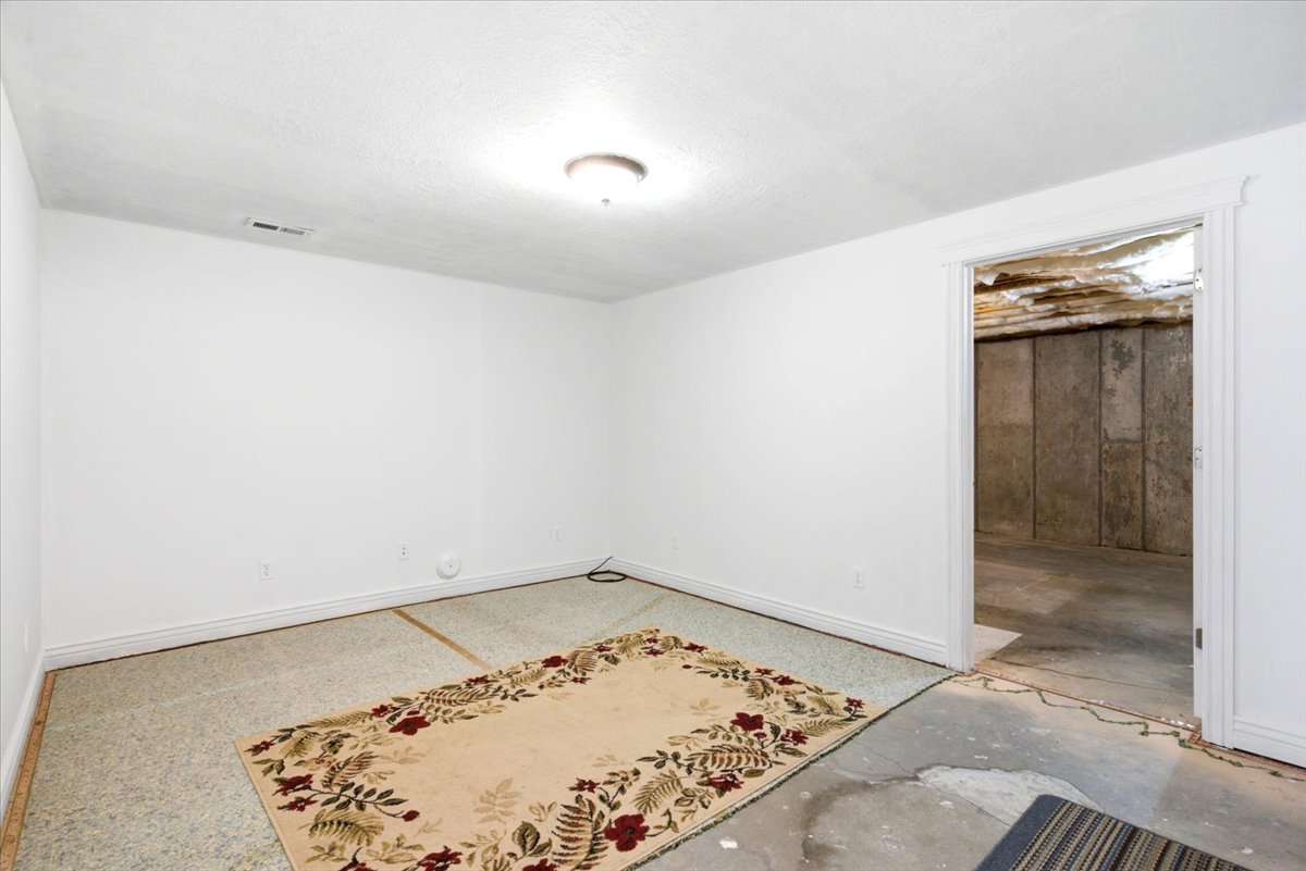 Finished room with a neutral color palette, baseboard trim, and a ceiling-mounted light fixture