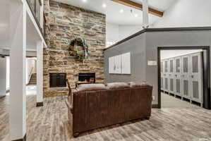 Floor-to-ceiling stone fireplace feature with a raised hearth and built-in wood storage