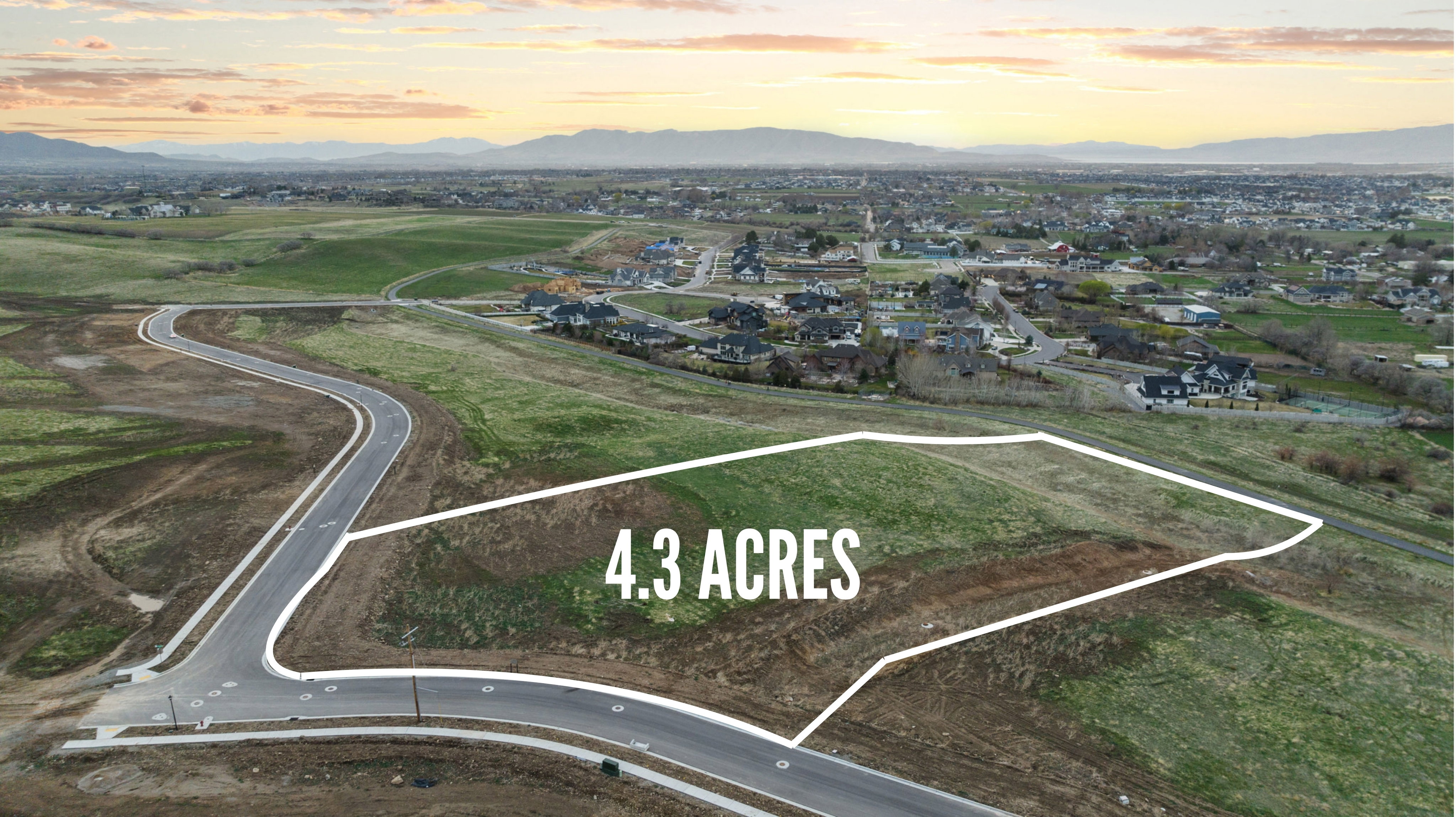 Expansive 4.3-acre parcel featuring gently sloping terrain and paved road frontage