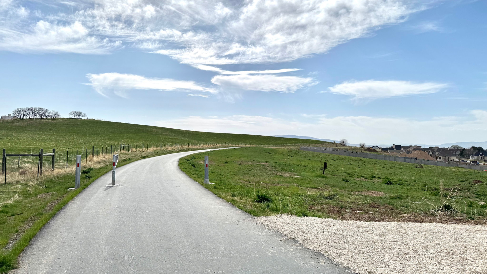 Paved pathway curving through expansive green terrain