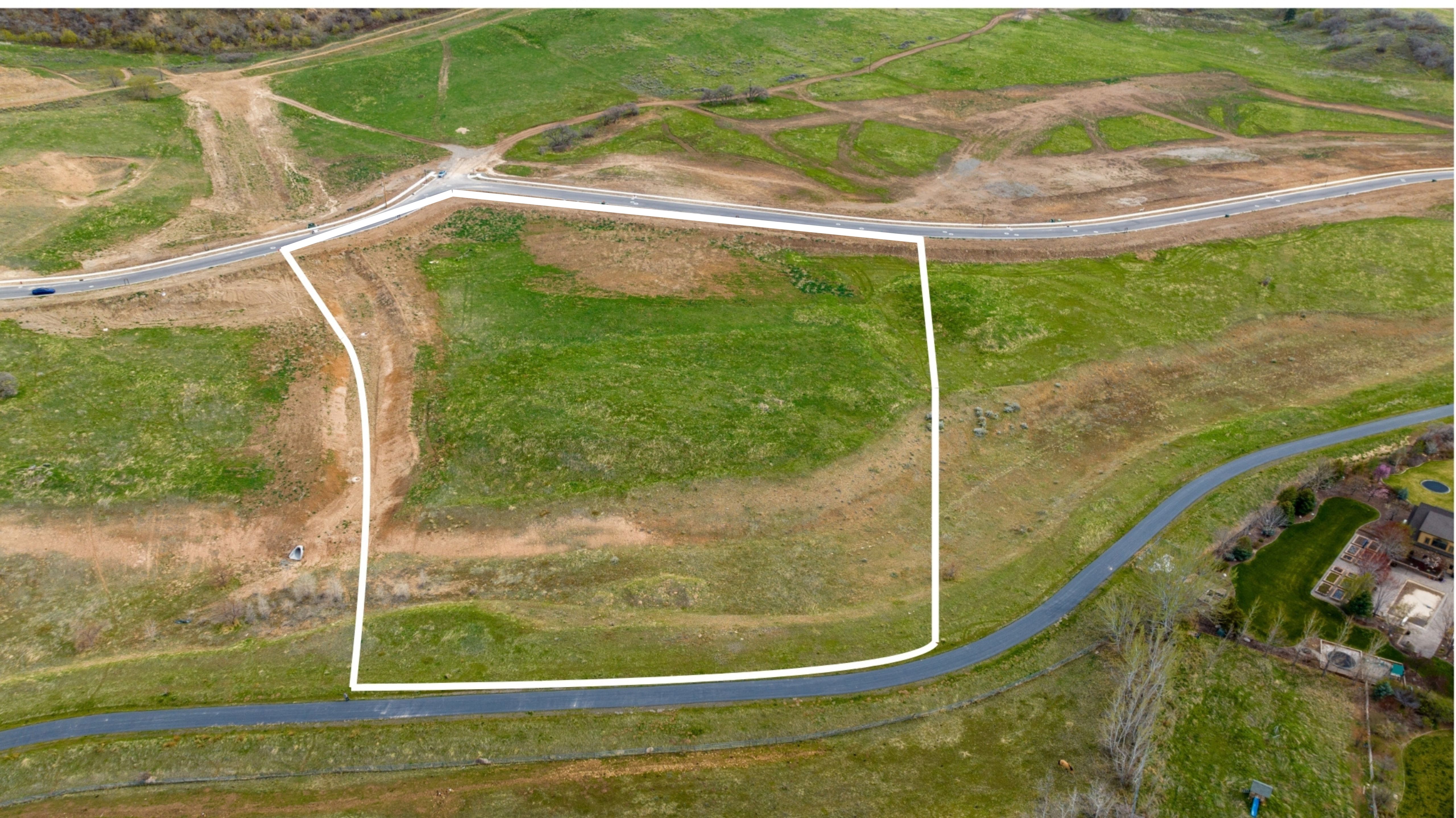 Expansive parcel featuring a defined boundary, surrounding green spaces, and direct road frontage