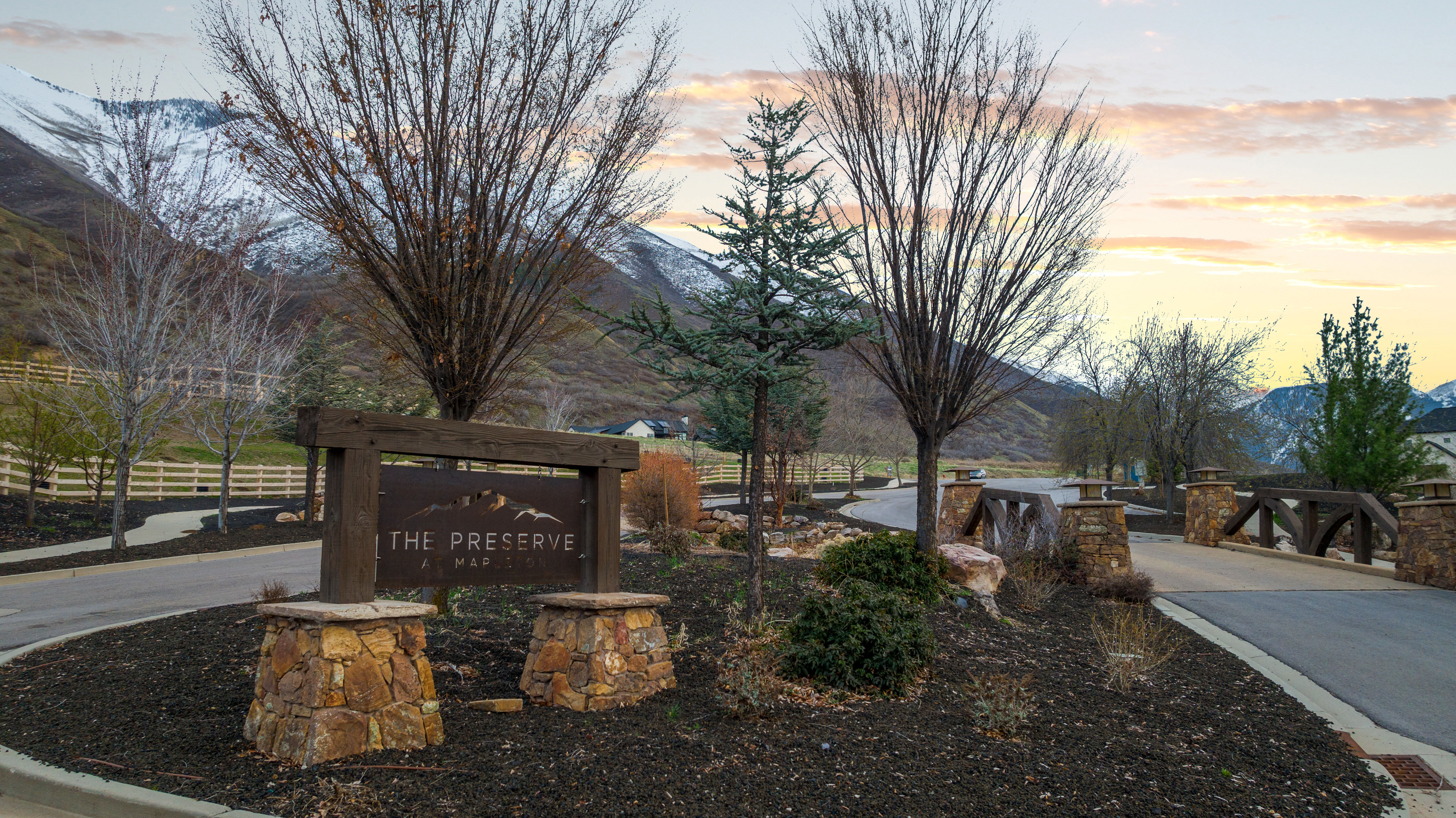 The Preserve entry sign crafted from wood and stone, set against a backdrop of mountainous terrain