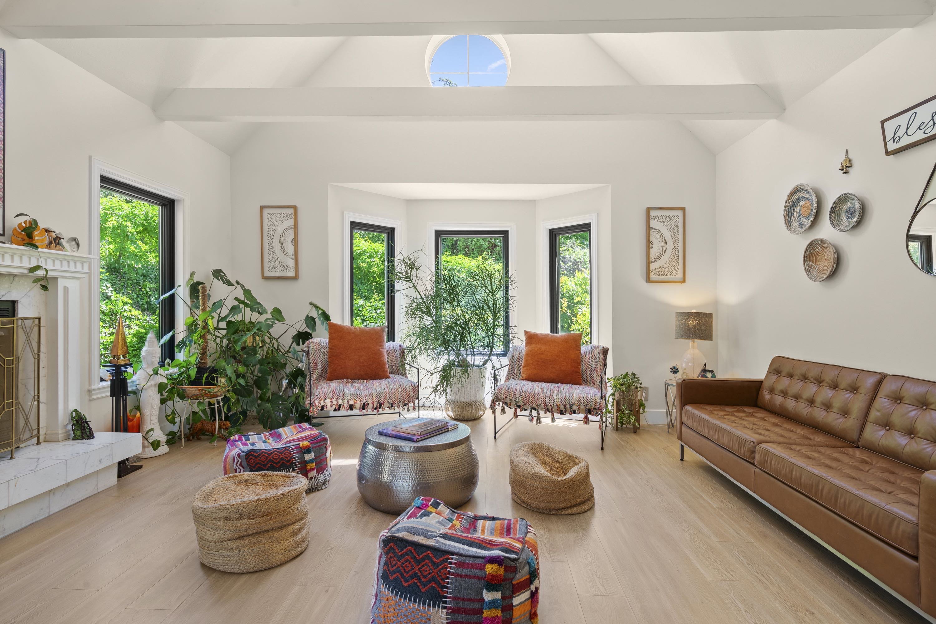 Vaulted ceiling with exposed beams and a circular skylight