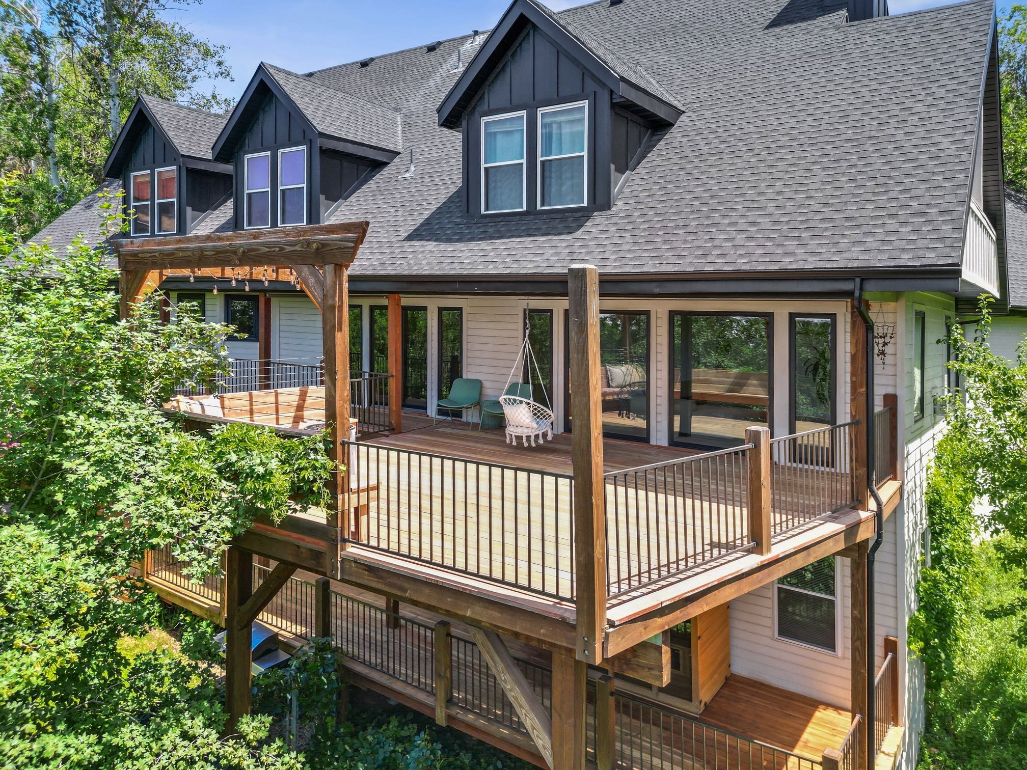 Multi-level outdoor decking with black metal railings and a pergola