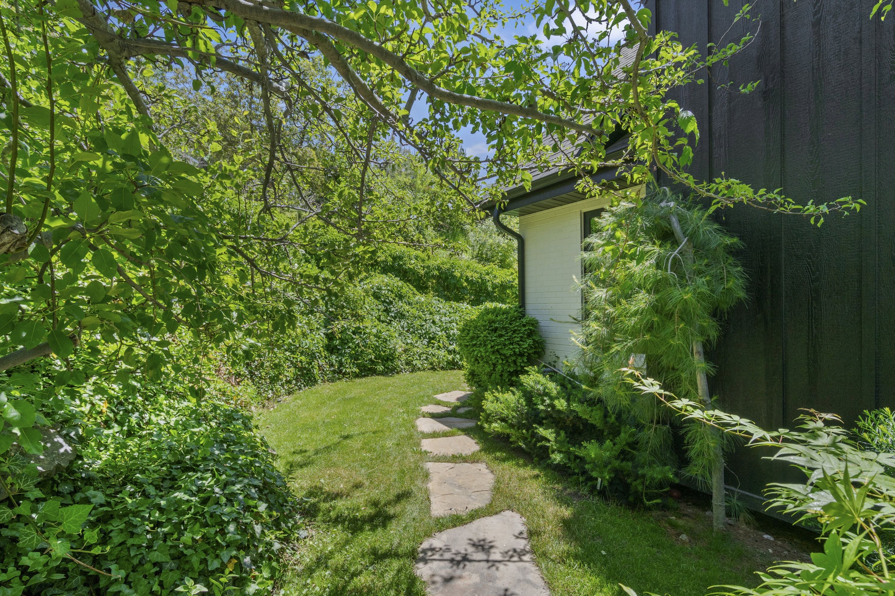 Stone pathway bordered by manicured lawn and lush foliage