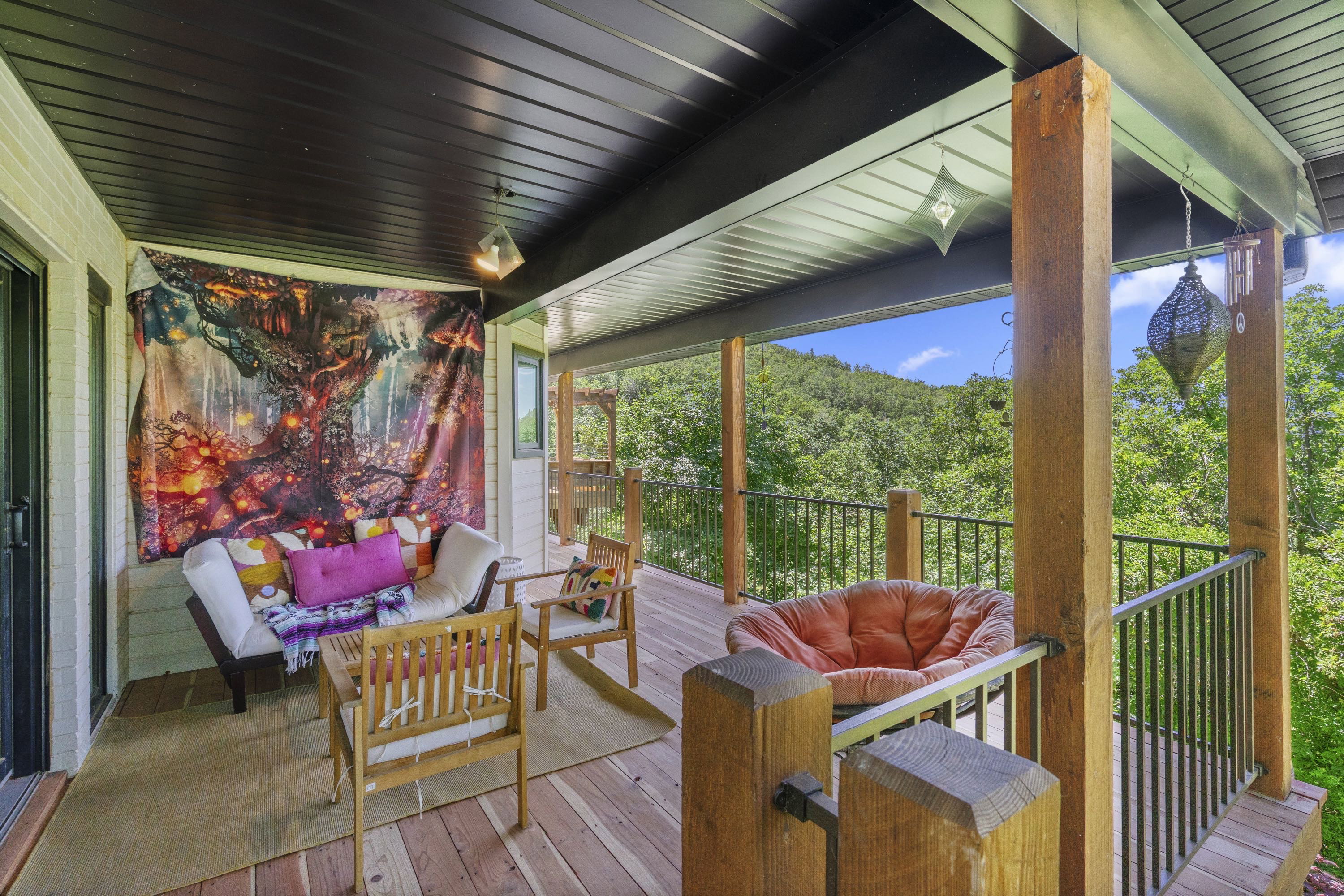 Expansive covered outdoor deck featuring wood plank flooring and a dark paneled ceiling