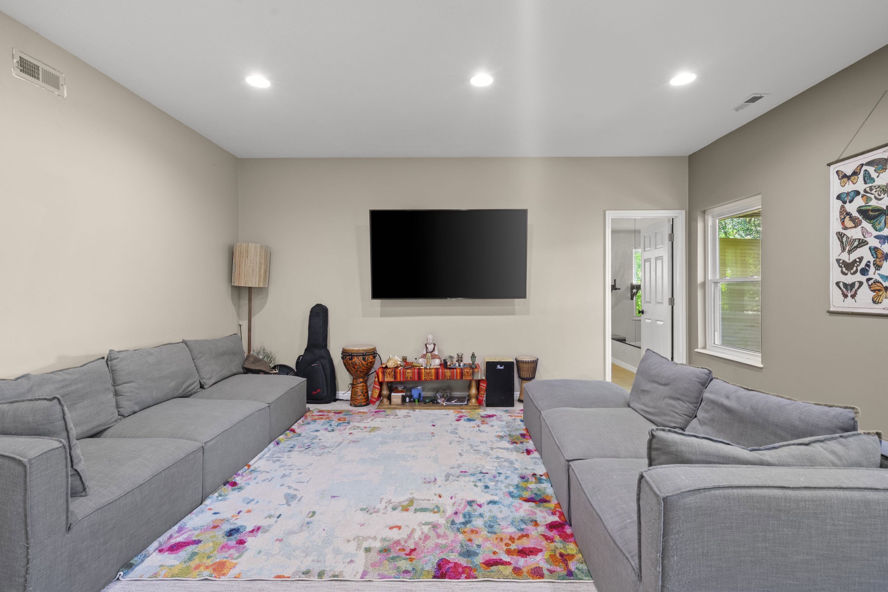 Expansive living space featuring light-toned walls, recessed lighting, and wood-finish flooring