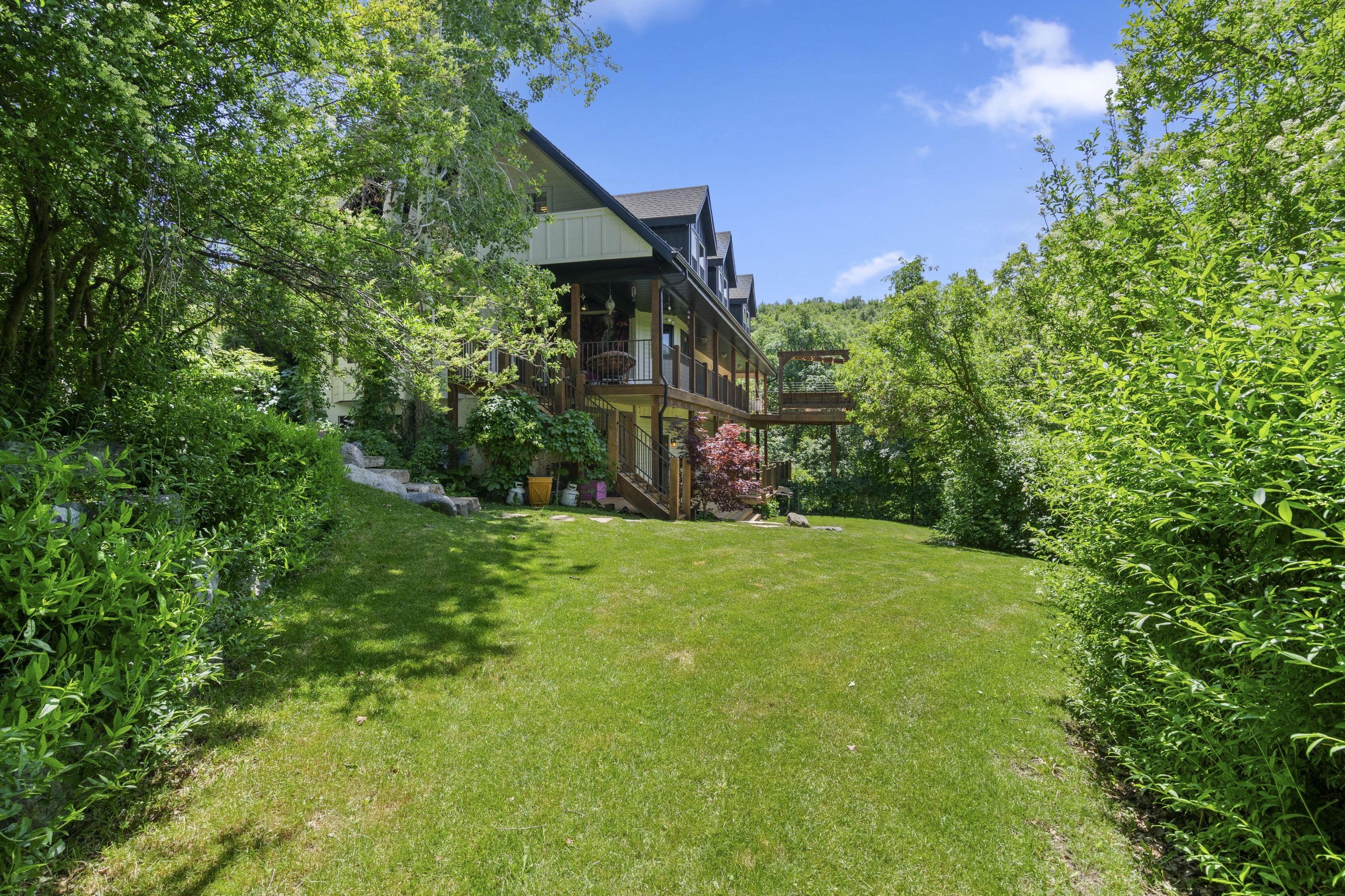 Expansive green lawn surrounded by mature trees and lush landscaping