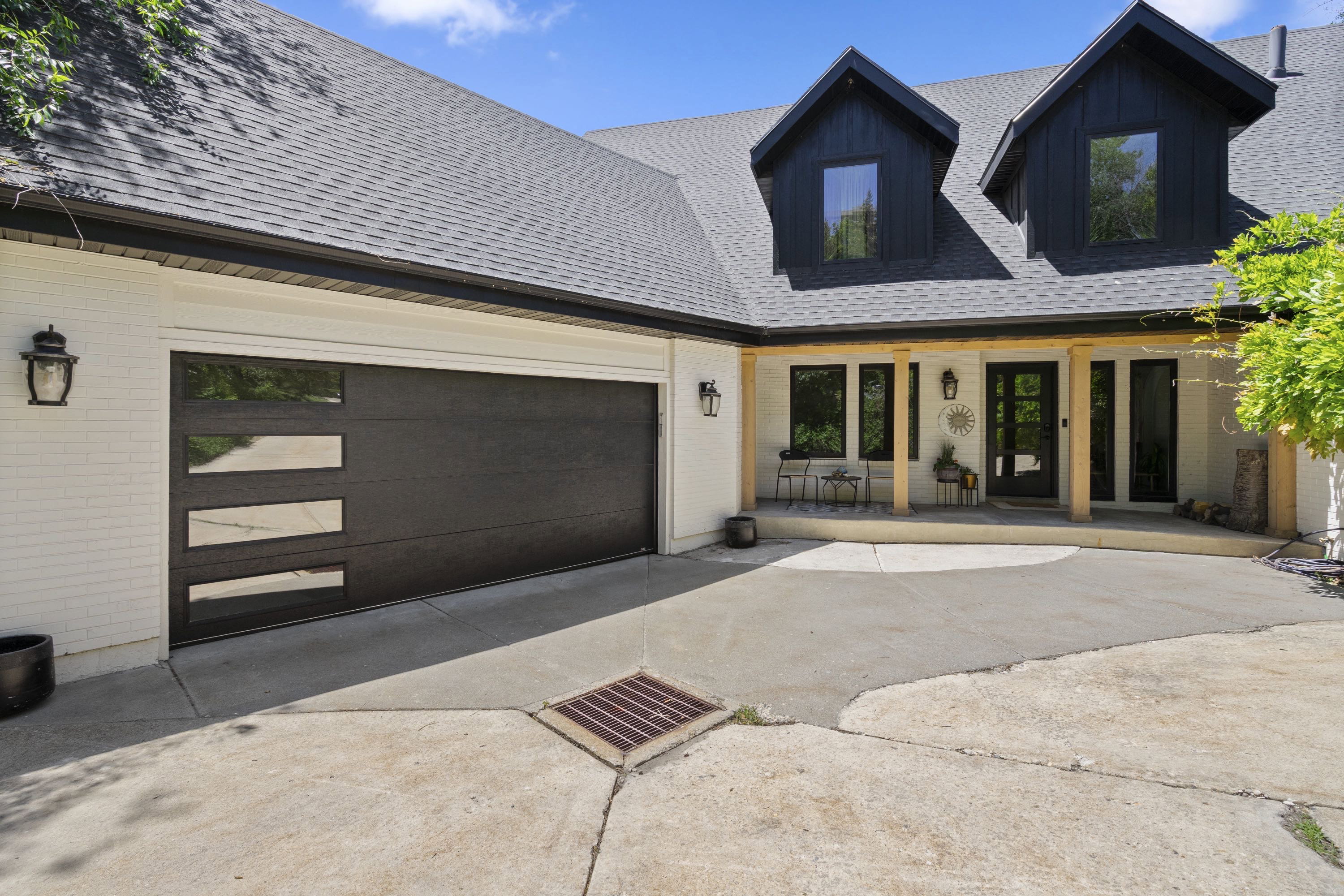 Contemporary exterior featuring white brick siding and a dark shingle roof