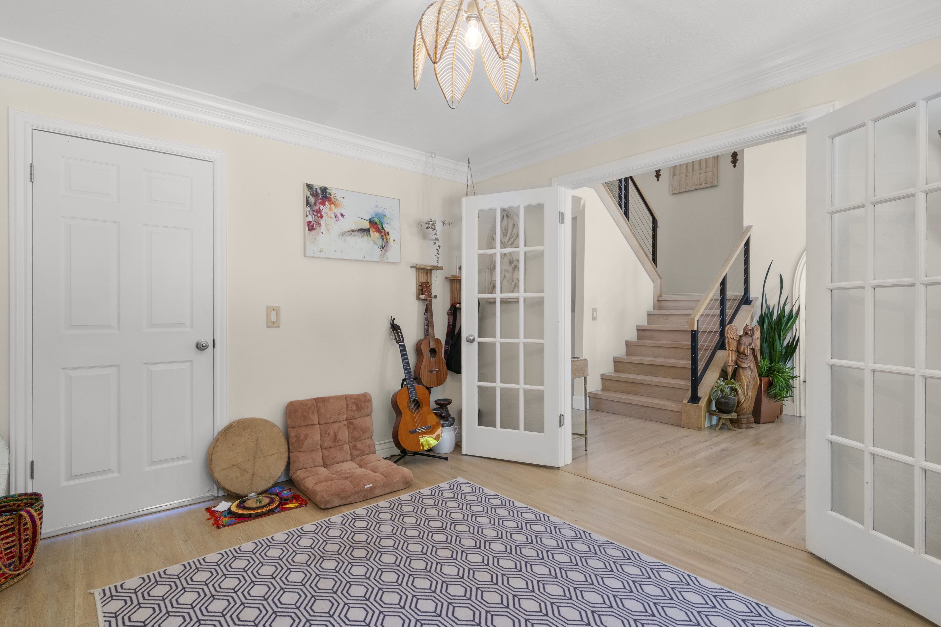 Bright interior space featuring wood-finish flooring, white trim, and a decorative ceiling light fixture