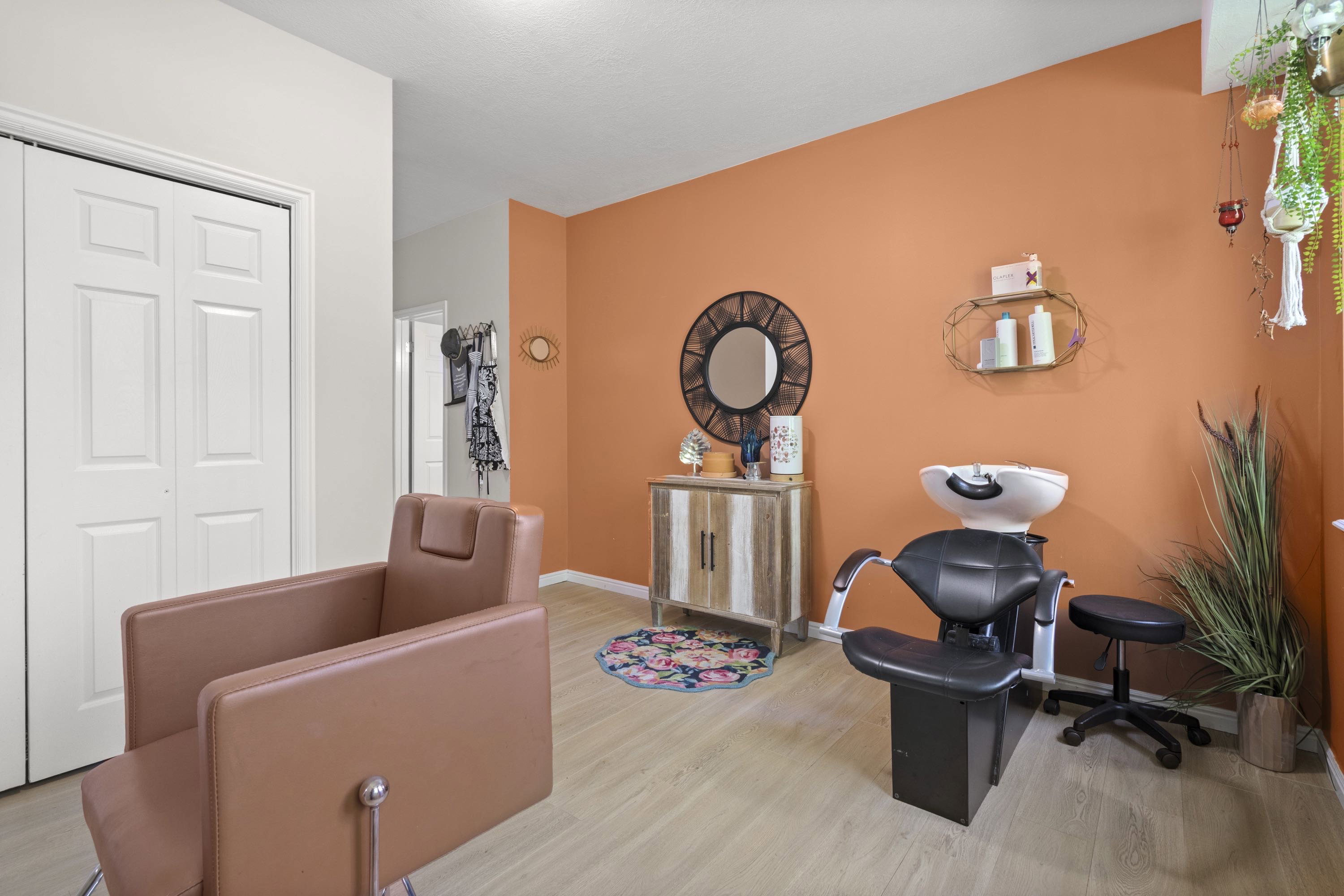 Versatile interior space featuring warm orange accent walls and light wood-finish flooring