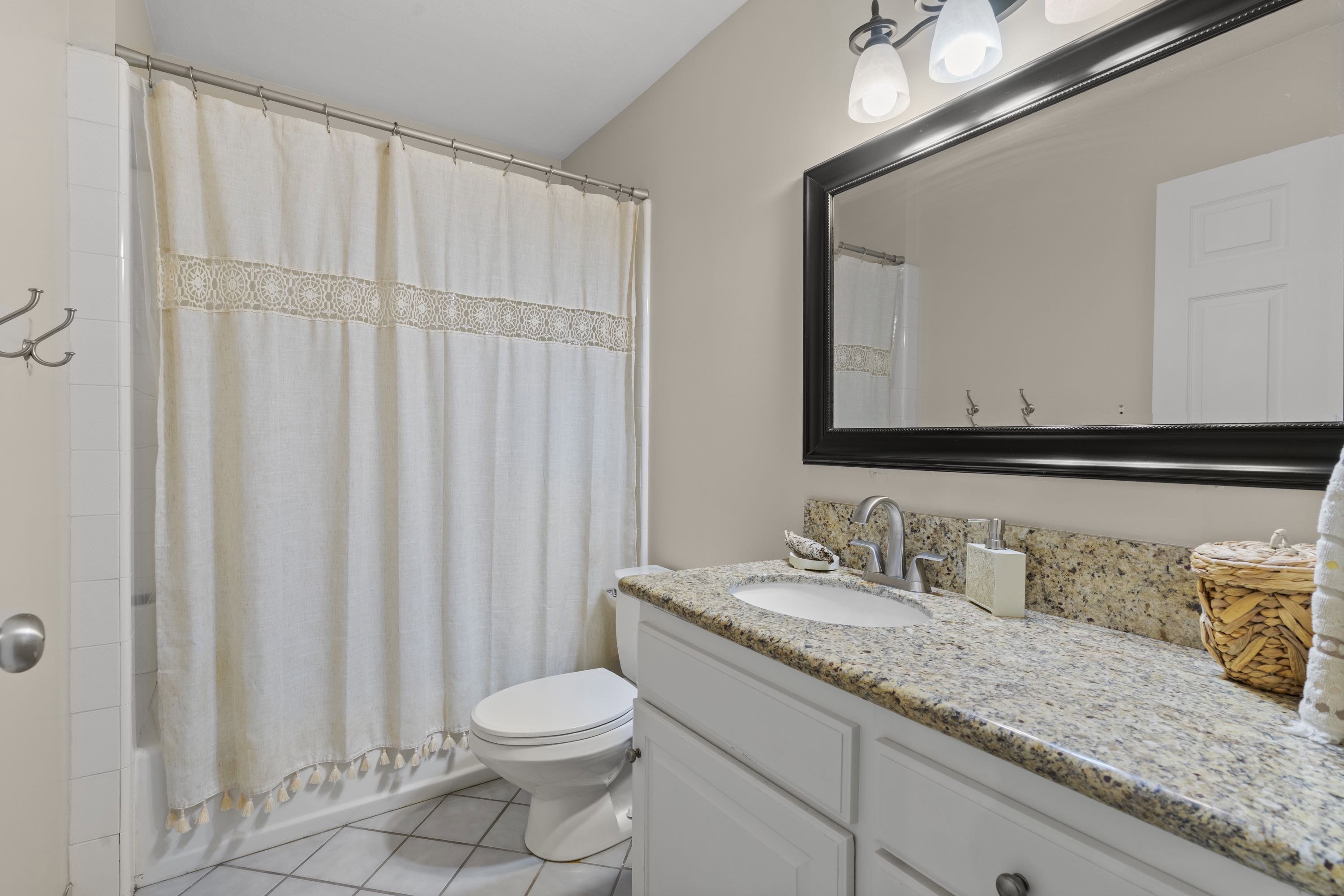 Bathroom featuring a spacious vanity with a granite countertop, undermount sink, and chrome faucet