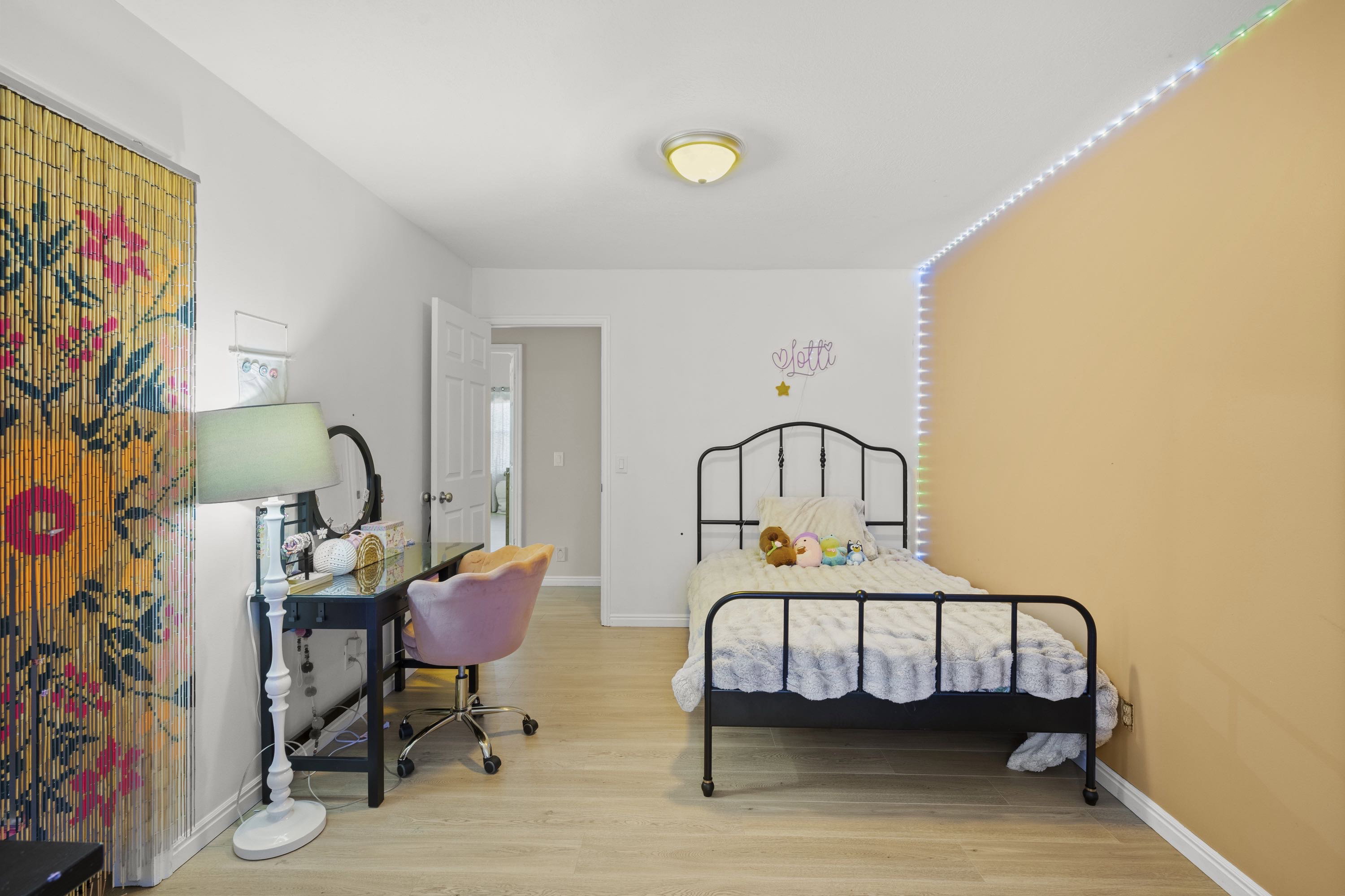 Interior space featuring light wood-finish flooring, a neutral wall color, and a partial accent wall