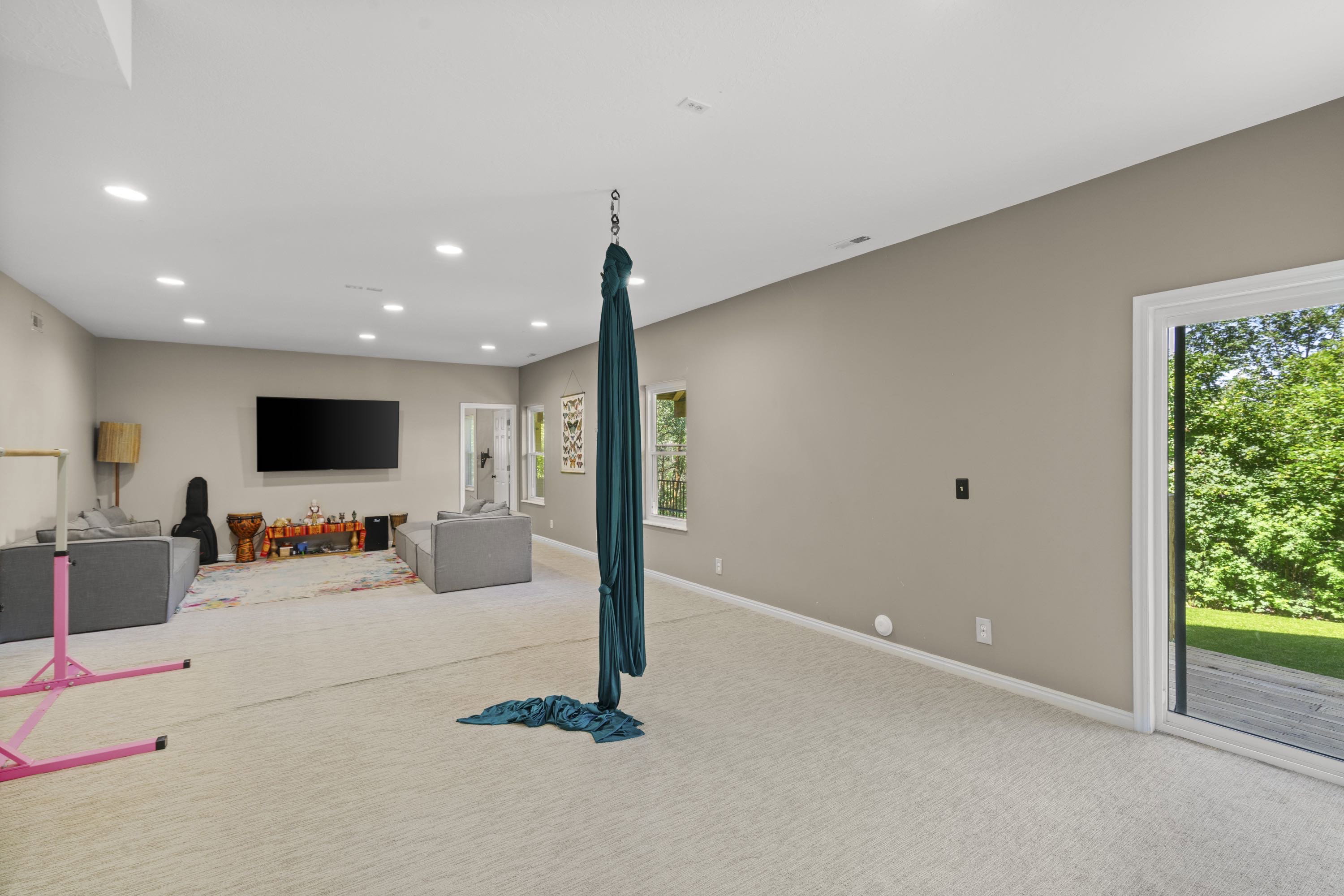 Spacious room featuring light neutral walls and carpeted flooring