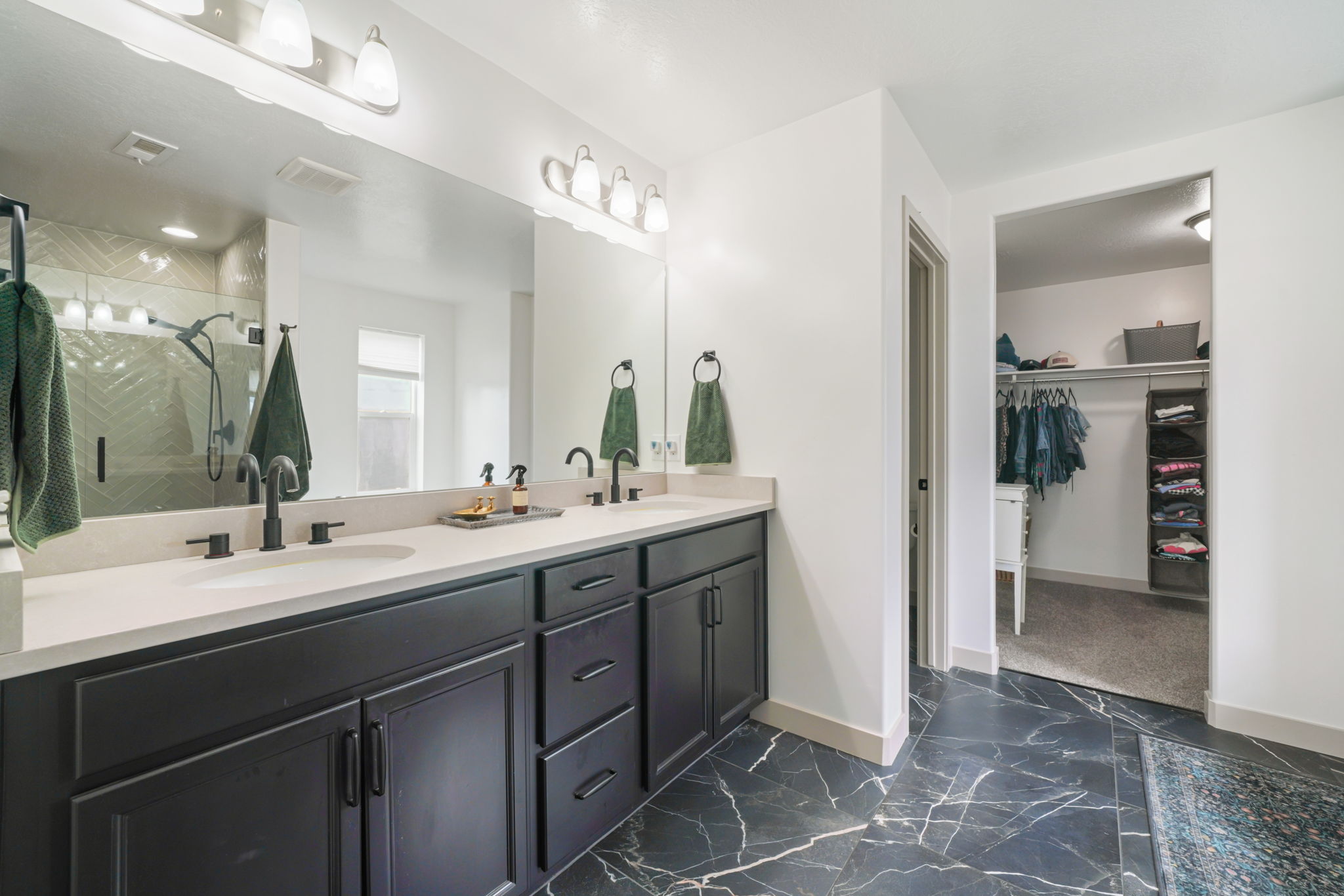Double vanity with light-toned countertop, black cabinetry, and matte black fixtures