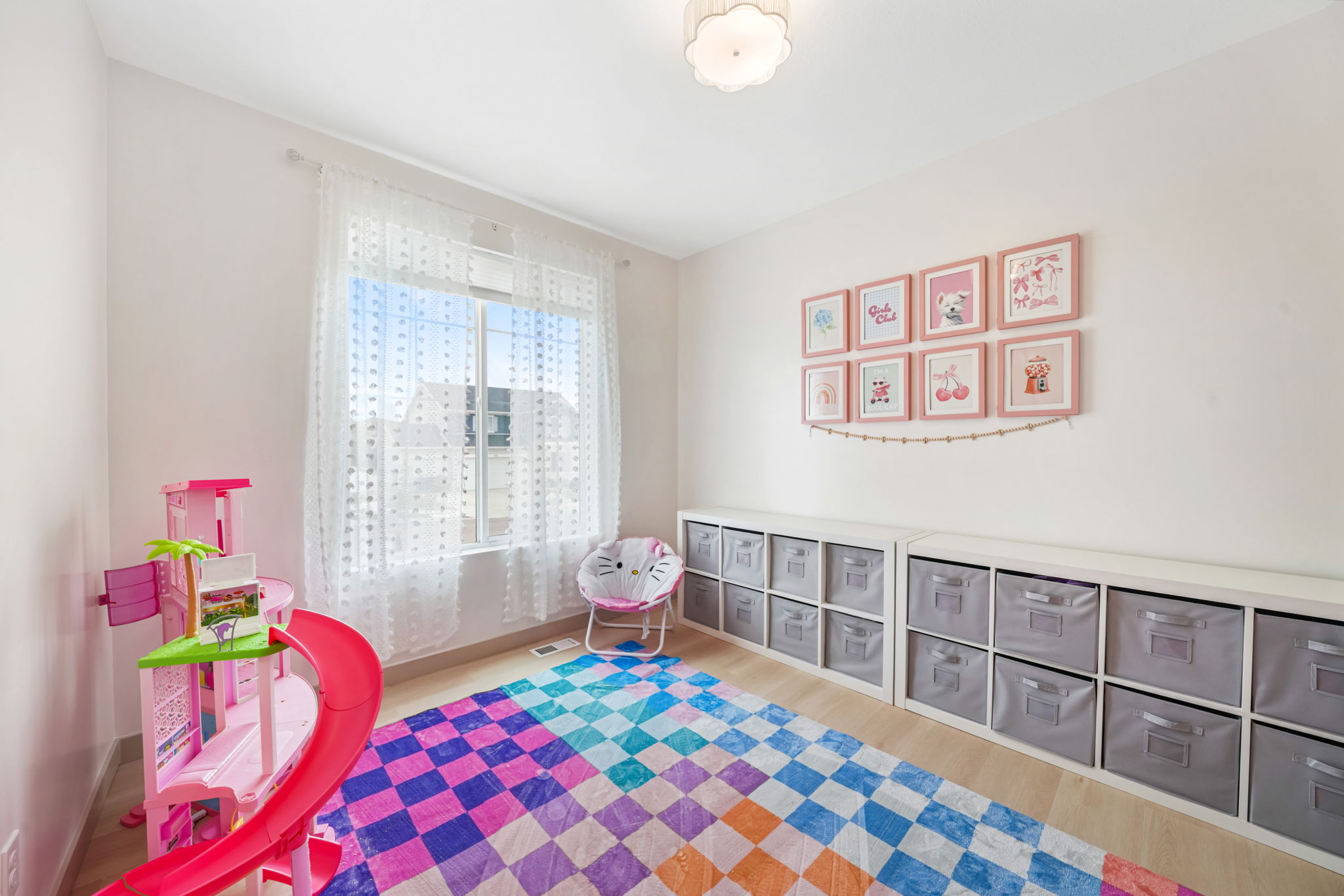 Bright interior space featuring a double window with sheer curtains, recessed lighting, and wood-finish flooring