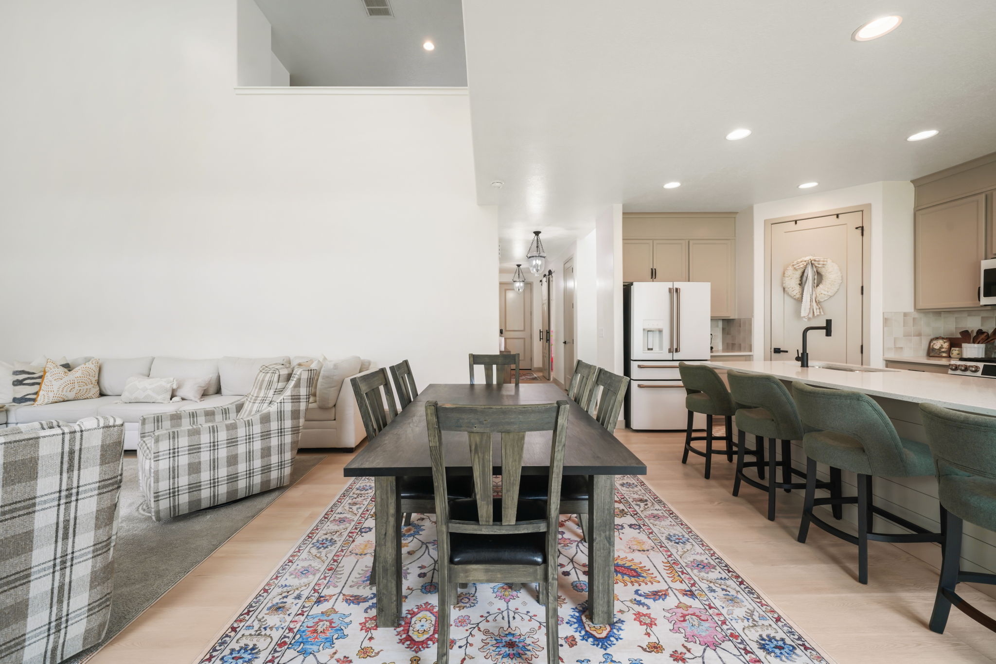 Open-concept main living area featuring light wood-finish flooring, recessed lighting, and a kitchen with light-toned cabinetry and a white countertop