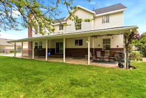 Private, fully fenced backyard with covered patio, shade trees, play area, swingset and RV parking
